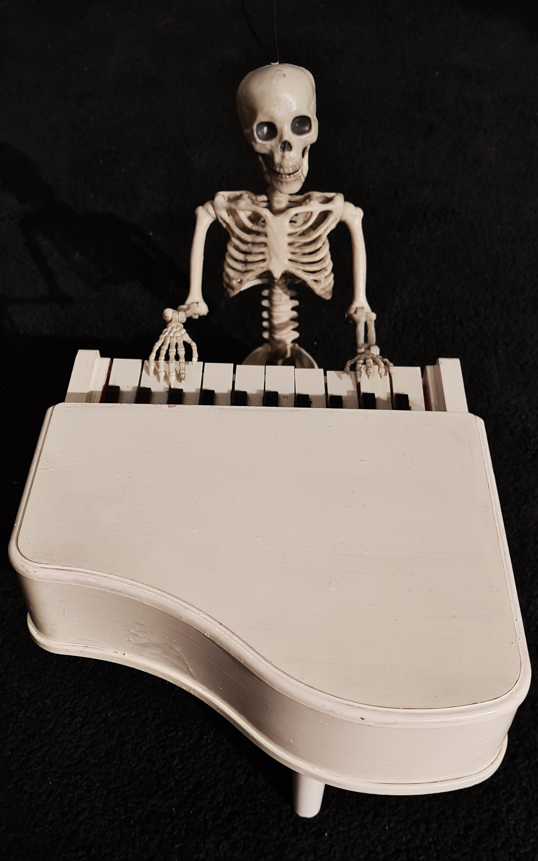 Skelettet Ben spelan piano